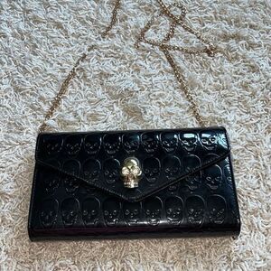 Awesome patent leather skull embossed clutch bag with gold chain shoulder strap.